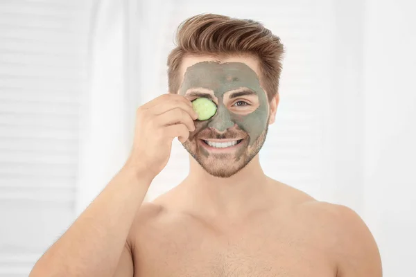 Молодой человек в косметической маске на лице в ванной комнате — стоковое фото