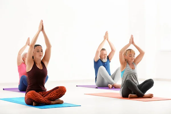 Gruppo di persone mature a lezione di yoga in casa — Foto Stock