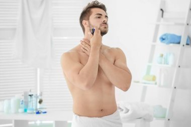 Yakışıklı genç adam tıraş oluyor. 