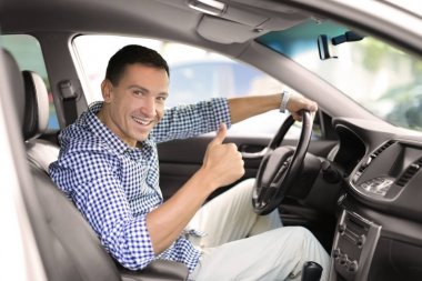 Arabada oturan ve başparmak gösterilmesini mutlu adam