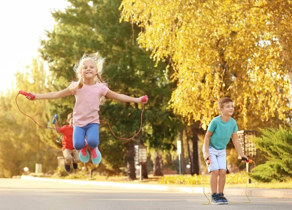 Adorabili bambini che saltano la corda all'aperto — Foto Stock