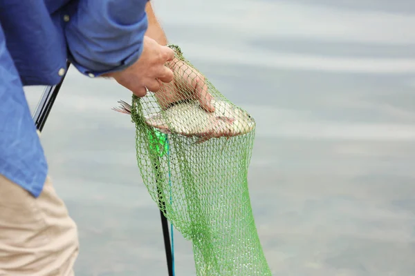 Fischer nimmt gefangenen Fisch — Stockfoto