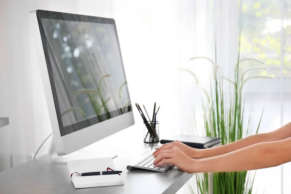 Junge Frau arbeitet mit modernem Computer am Tisch — Stockfoto
