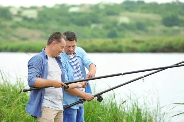 Мужчины рыбачат с берега на реке — стоковое фото