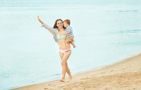 Lycklig mamma med lille son på stranden — Stockfoto