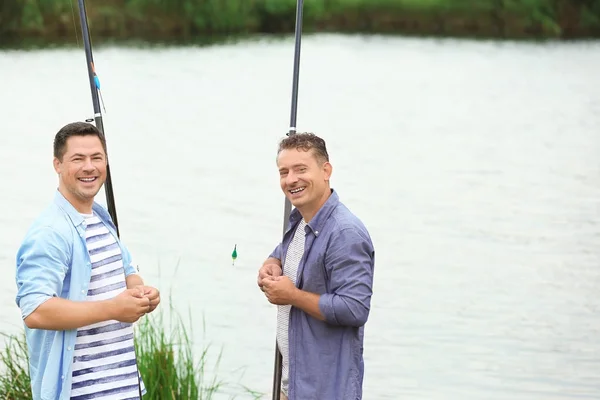 Homens que pescam a partir da costa no rio — Fotografia de Stock