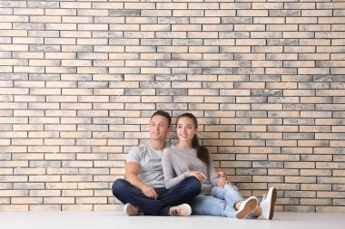 Mutlu genç çift tuğla duvar yeni apartmanda yakın katta oturuyor. Hareketli ev kavramı