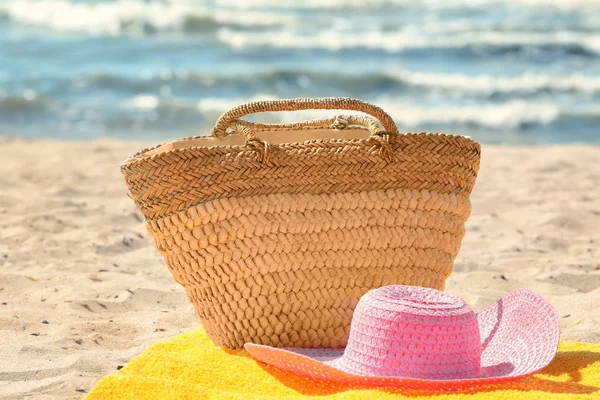 Toalla de playa con sombrero de verano y bolso en arena —  Fotos de Stock