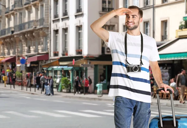 Joven turista con cámara y maleta al aire libre — Foto de Stock