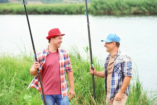 Dos pescadores con cañas a orillas del río — Foto de Stock