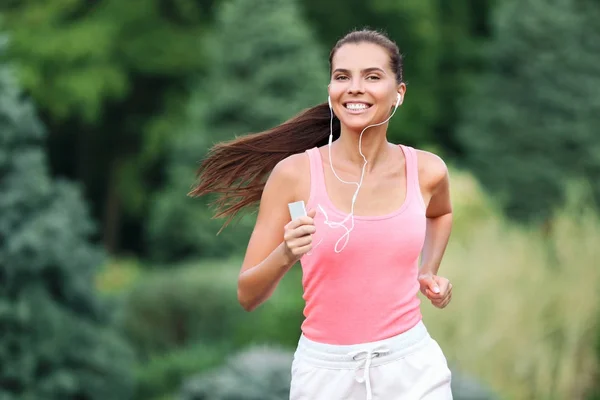 Giovane donna sportiva che corre nel parco — Foto Stock