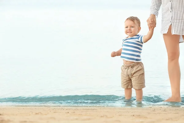 Mãe feliz com filho pequeno na praia — Fotografia de Stock