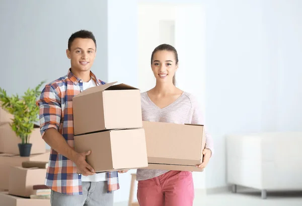 Feliz pareja joven con cajas móviles en su nuevo apartamento — Foto de Stock