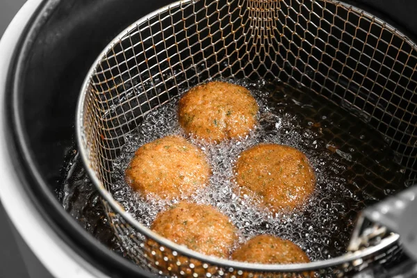 Salmon patties deep frying in basket — Stock Photo, Image