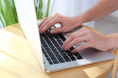 Laptop ile masada çalışan genç kadın