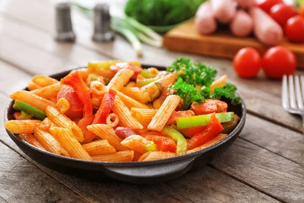 Pasta with sausage in portioned frying pan — Stock Photo, Image