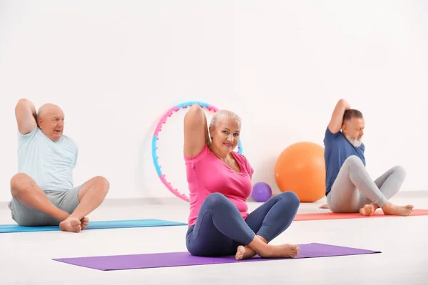 Grupo de personas maduras en clases de yoga en interiores —  Fotos de Stock