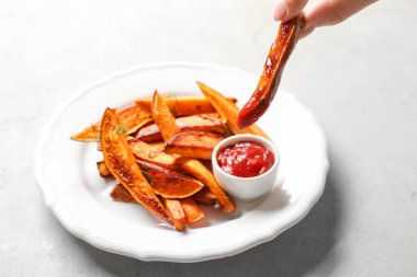Tatlı patates kızartma sosu ile tutan kadın