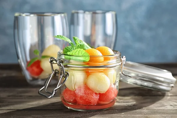 Glass jar with melon balls on table — Stock Photo, Image