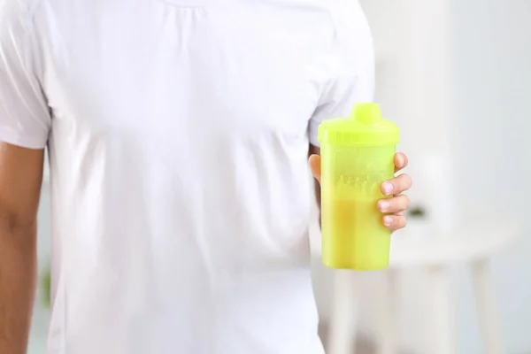 Joven sosteniendo botella con batido de proteínas en el interior — Foto de Stock