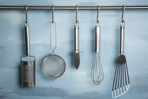 Metal kitchen utensils hanging on rack — Stock Photo, Image