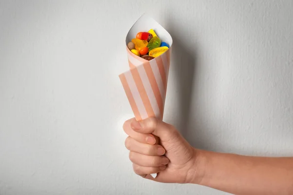 Woman holding paper cone with colorful candies — Stock Photo, Image