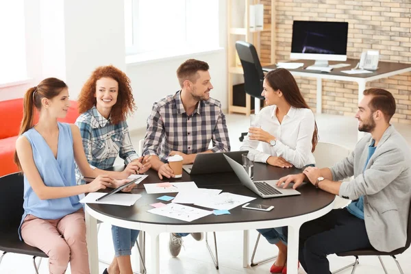 Team of young professionals conducting business meeting in office