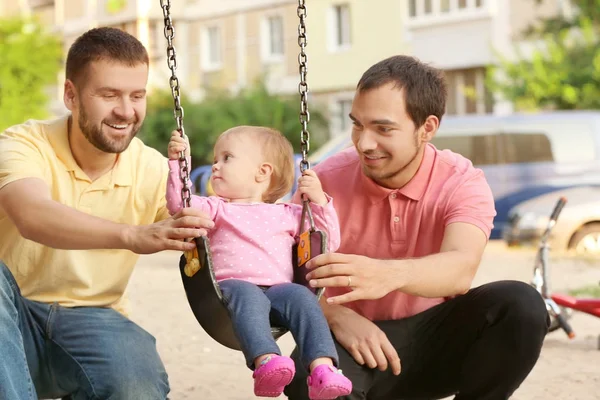 Male gay couple with adopted baby girl, outdoors — Stock Photo, Image