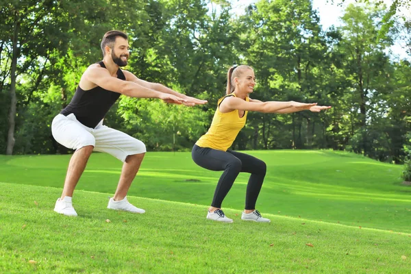 Joven pareja deportiva haciendo ejercicio en parque verde — Foto de Stock