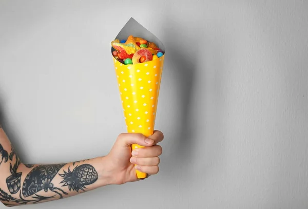 Woman holding paper cone with colorful candies — Stock Photo, Image