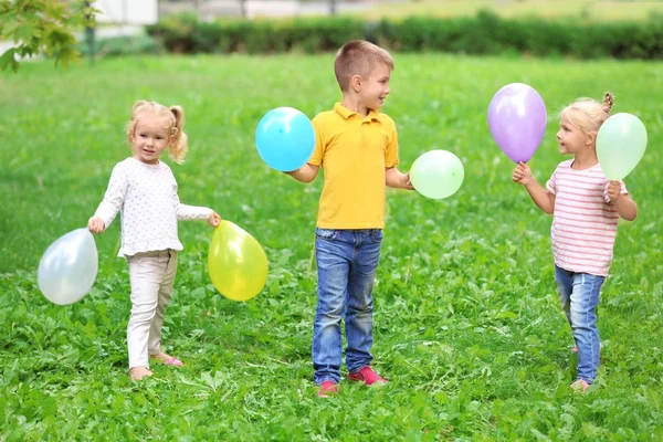Lindos niños con globos en el parque —  Fotos de Stock