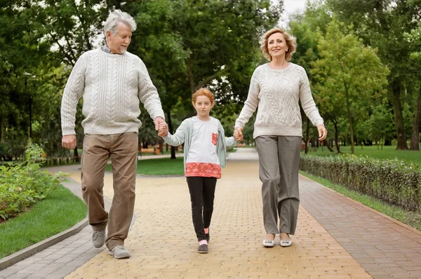 Kleines Mädchen mit Großeltern spazieren im Park — Stockfoto