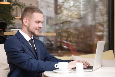 Yakışıklı işadamı sokak kafede dizüstü bilgisayar ile çalışma