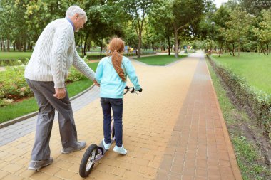 Komuta sizde onun torunu Park tekme scooter binmek kullanmayı öğretmek