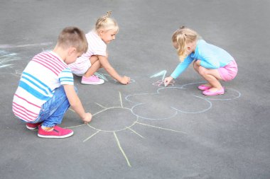Sevimli küçük çocuklar tebeşir ile asfalt üzerinde çizim