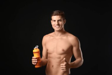 Protein shake ile şişe tutan genç adam