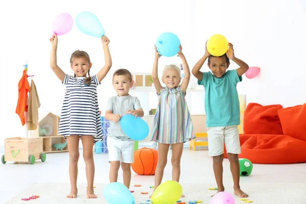 Милые дети играют с воздушными шарами в помещении — стоковое фото