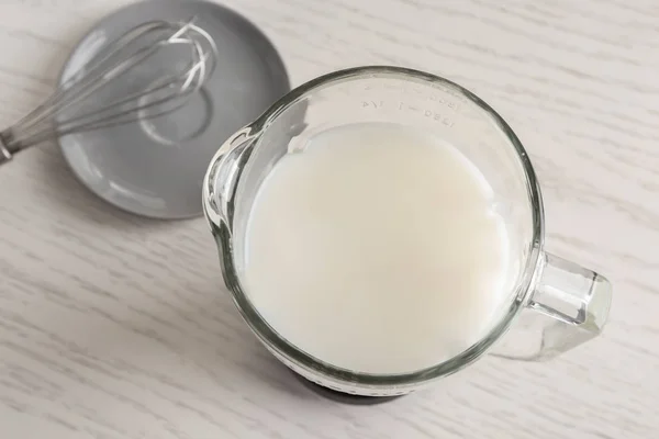 Glass jug with yogurt for making pudding — Stock Photo, Image