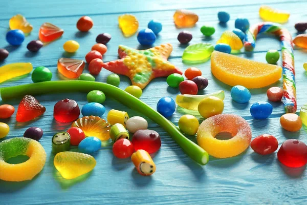 Bunte Bonbons auf blauem Hintergrund verstreut — Stockfoto