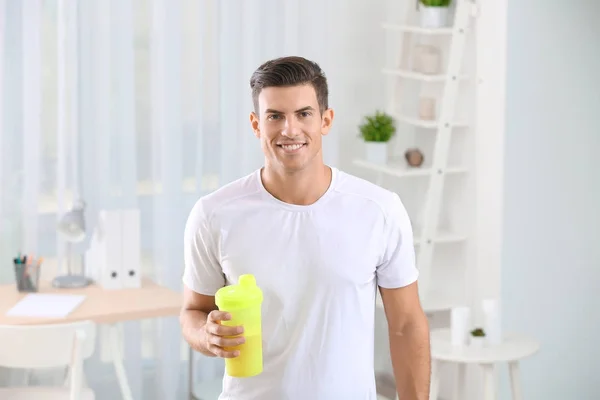 Protein shake ile şişe tutan genç adam — Stok fotoğraf