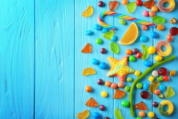 Bunte Bonbons auf blauem Hintergrund verstreut — Stockfoto