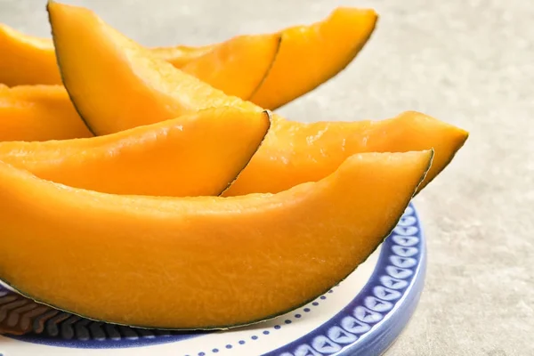 Piatto con melone affettato sul tavolo — Foto Stock