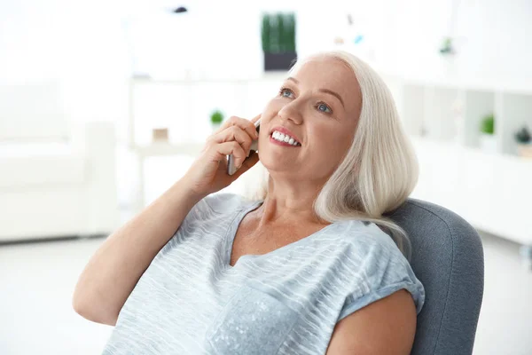 Mulher sênior falando no celular em casa — Fotografia de Stock