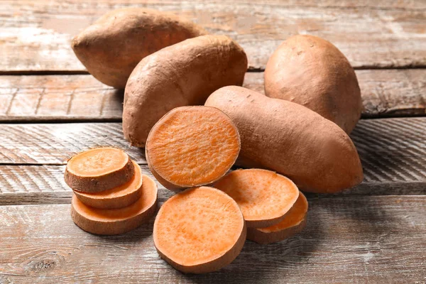 Sweet potatoes on wooden table — Stock Photo, Image