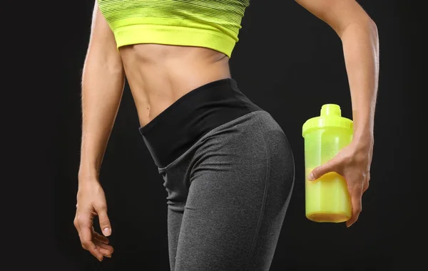 Joven mujer sosteniendo botella con batido de proteínas —  Fotos de Stock