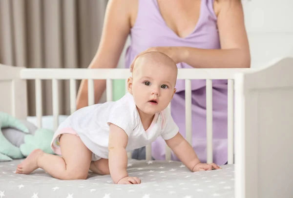 Bayi lucu di tempat tidur bayi dan ibu di rumah — Stok Foto