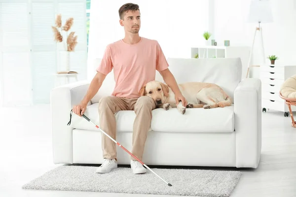 Blinde man met geleidehond zittend op de Bank thuis — Stockfoto