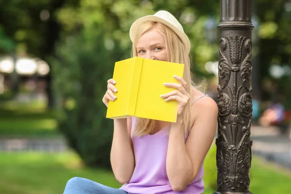 Belle jeune femme lecture livre dans le parc de la ville — Photo