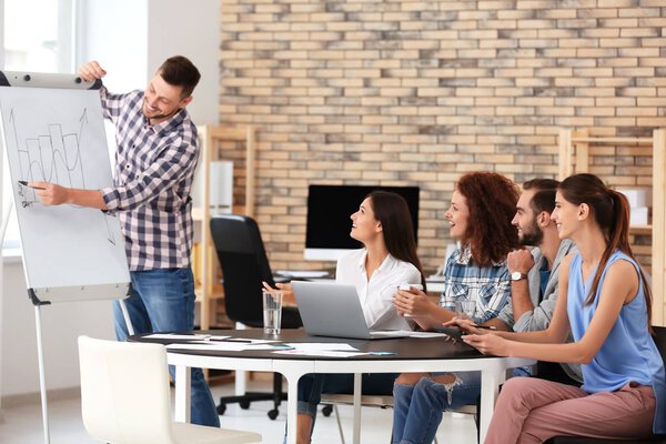 Team of young professionals conducting business meeting in office