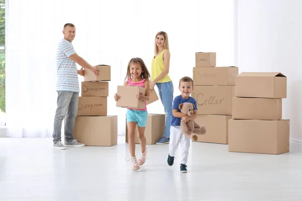 Família com caixas de papelão em nova casa — Fotografia de Stock